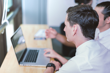 Business, technology, internet and networking concept. Young male businessman sitting at a desk in the office.の写真素材