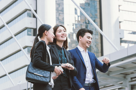 Group of happy Asian business colleagues laughing and talking enjoy outside the office.の写真素材