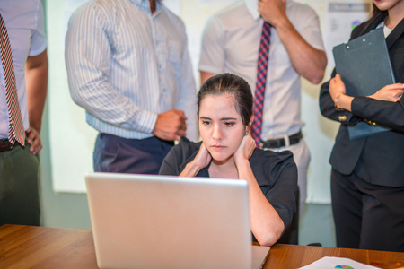 business asian woman working on computer and reading required information on portable laptop,female secretary look like serious and stressed with her job hold the head with hand with boss pressureの写真素材
