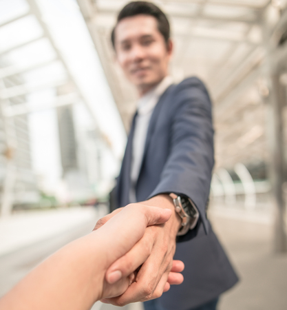 Business handshake concept. shaking hand of two businessman closing a deal city backgroundの写真素材