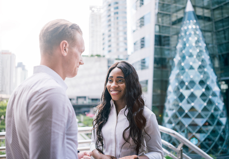 Happy Business colleagues walking outside office & talking to each other.の写真素材
