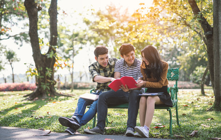 Young people studying reading book in park. education study by read.の写真素材