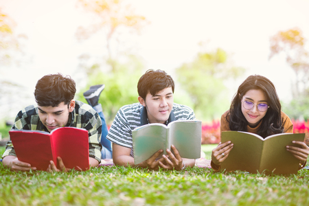 Young people studying reading book in park. education study by read. の写真素材