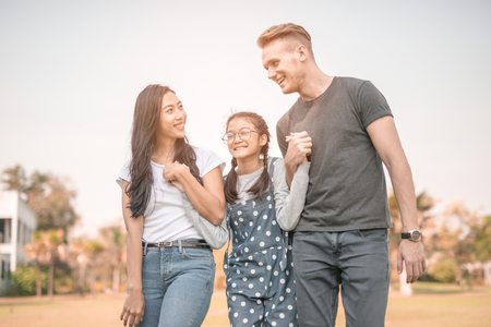 Happy young couple spending time with their daughter in park.The concept of a happy family.の写真素材