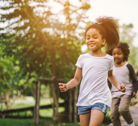 Cute african american little girl playing outdoor - Black people kid and friend happy.の写真素材