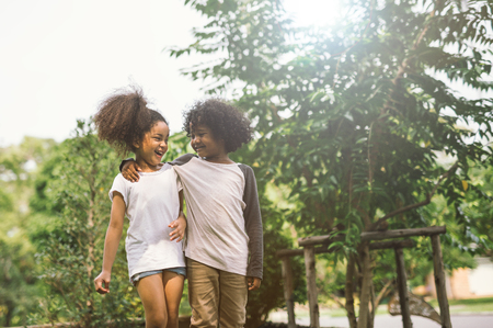 Children Friendship Togetherness Smiling Happiness Concept.Cute african american little boy and girl hug each other in summer sunny dayの写真素材