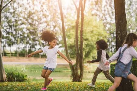 Cute african american little girl playing outdoor - Black people kid and friend happy.の写真素材