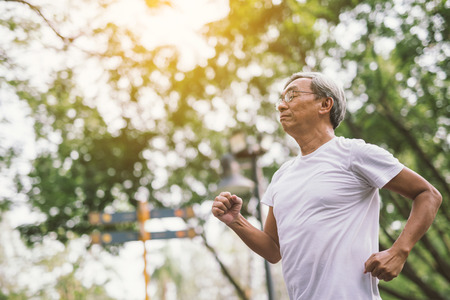 Asian senior mature man running Jogging In Parkの写真素材