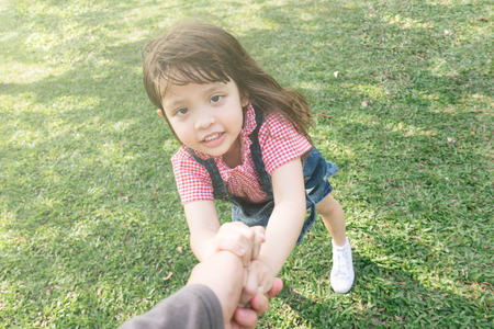 little cute girl holding hands parents looking at cameraの写真素材