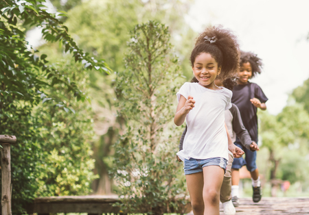 Cute little girl playing outdoor. kid and friend happy play at park.の写真素材