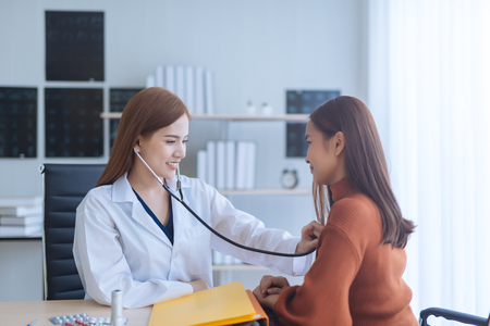 Asian woman doctor examining woman in a hospitalの写真素材