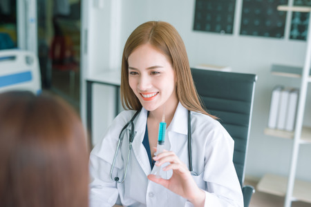 Young asian doctor showing hand press syringe ready to inject shot  Vaccination and medical injection image.Healthcare, Medical vaccine concept.の写真素材