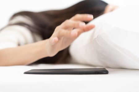 Blur Woman woke up by smartphone alarm clock and turning off snoozing phone alarm clockの写真素材