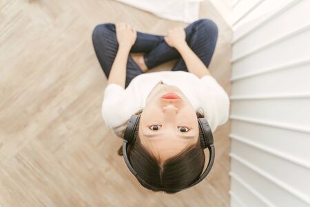 Cheeky Asian women relax by listening to music using headphones.の写真素材