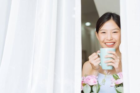 Portrait Asian woman relaxing with coffee at homeの写真素材