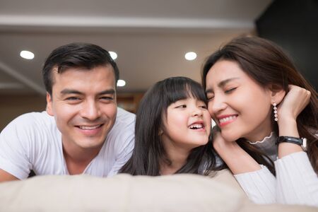 happy asian family spending time together on sofa in living room. family and home conceptの写真素材