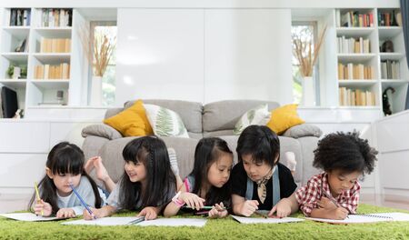 Group of little preschool kids drawing paper with color pencils . portrait of children friends...