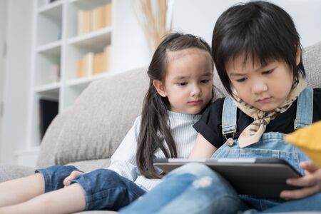 Children playing on tablet. Two kids playing with laptop together