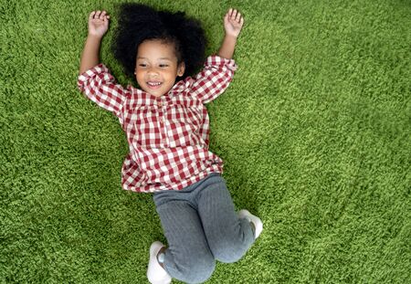 Happy children kids smiling and laying on green carpet floor in living room at home.