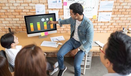 Indian business man and his team presentation on screen monitor by graph and chart show profit and meeting in modern office design planning ideas conceptの写真素材