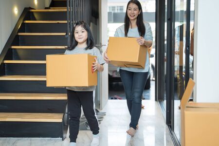Portrait of happy Asian family moving to new house with cardboard boxes.の写真素材