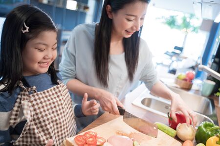 Daughter and mother preparing the sandwich and salad for breakfast in kitchen.の写真素材