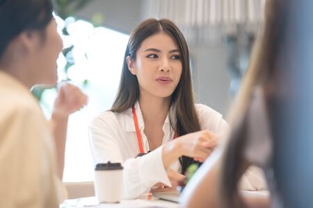 Young Asian woman and business people are meeting in office discussion with colleagues . Group of Business team working and share ideas about project to partnersの写真素材