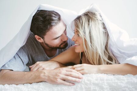 Young couple in the bed wake up in the morning. loving couple in bedroom