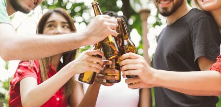 Group of friends toasting beers outdoors. Party people drinks toast celebration.