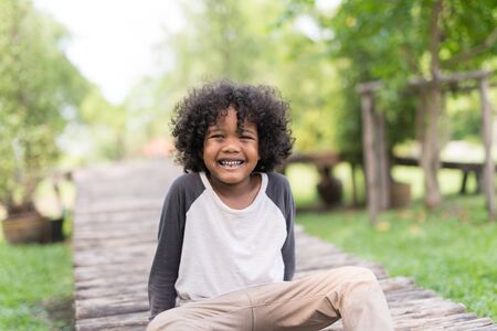 portrait of a cute African american little boy smiling at nature park.の写真素材
