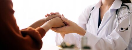 Doctor holding hands of patient  encouragement support cheering conceptの写真素材