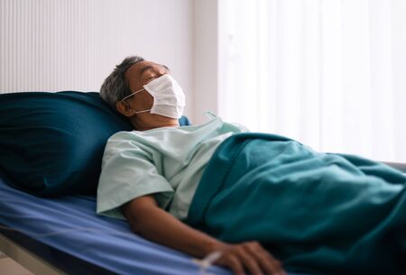 old mature patient  in hospital ward on hospital bed wear protection mask for prevent the spread of the virusの写真素材