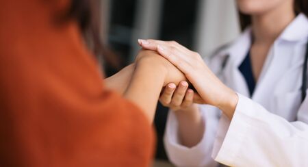 Doctor holding hands of patient  encouragement support cheering conceptの写真素材