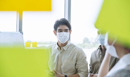 Group of Asian business people meeting and working in office and wear mask for protect  prevent infection corona virus covid 19.の写真素材