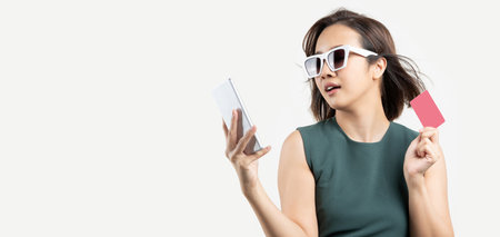 Young Asian woman with glasses shopping by phone and hold card for payment. Enjoy Happy Shop Credit...