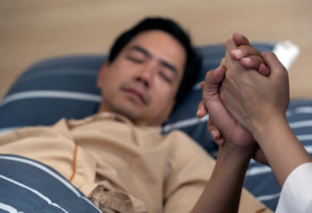 Holding the hand asian man patient in hospitalの写真素材