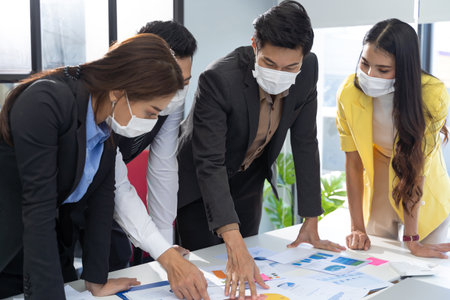 Group of Asian business people meeting and working in office and wear mask for protect  prevent infection corona virus covid 19.の写真素材