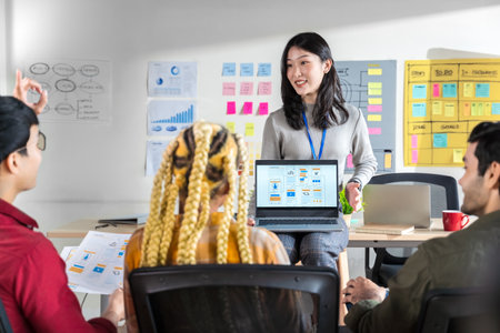 Asian female creative designers present ux ui to team.Designers team working meeting in a modern...