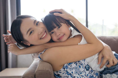 Asian mother and daughter smile and look at each other. Happy love family conceptの写真素材
