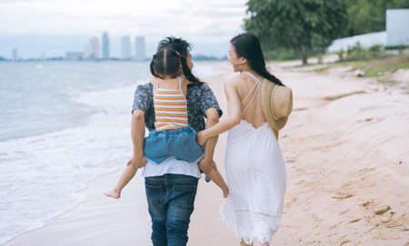 Asian Family walking at beach with kid Riding on the back. happy vacation family conceptの写真素材