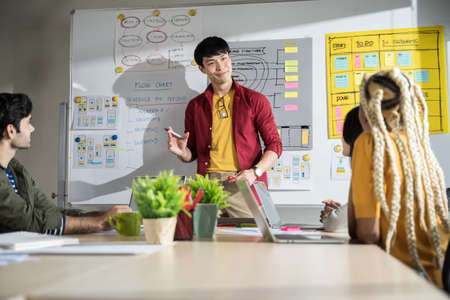 Businessman creative designers present their work to the team. Designers are meeting in a modern...