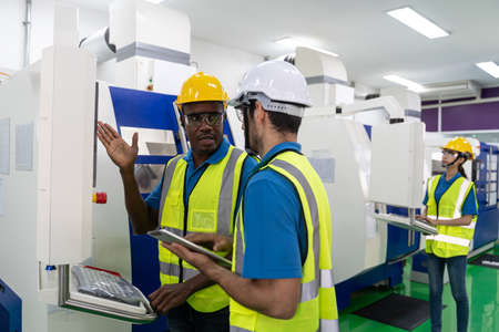 Portrait of foreman engineer working with machine in factory plant.