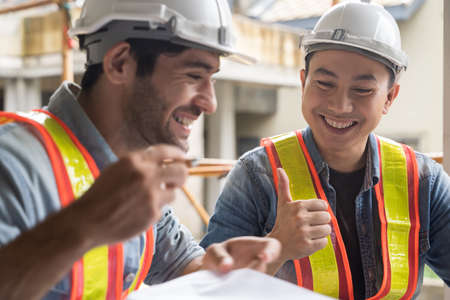 Team onsite of architecture inspector and discuss together and working at building siteの写真素材