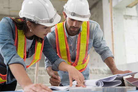 Working of engineer at building site talking and discussing on document . Teamwork site inspector...