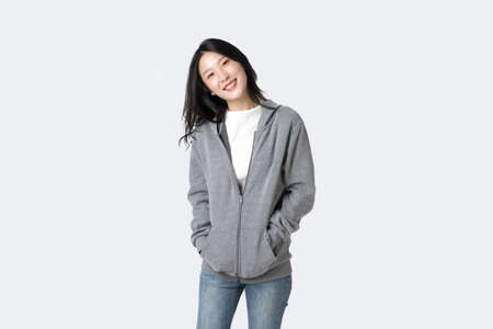 Portrait beautiful  Asian woman in hoodie sweatshirt and blue jeans isolated over white backgroundの写真素材