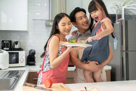 Asian happy family preparation breakfast together in kitchen After cooking, take a picture and look at the camera together.の写真素材