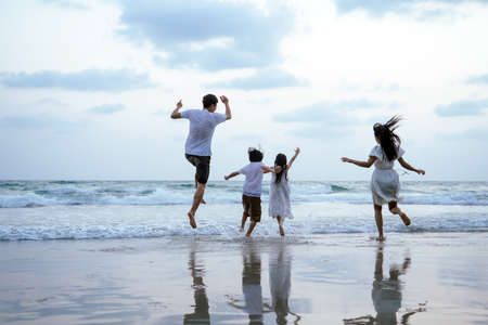 Asian Family running and jumping together at beach with kids happy vacation travel beach conceptの写真素材