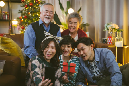 Asian family taking selfie near Christmas tree together at home. Family, holidays, Christmas conceptの写真素材