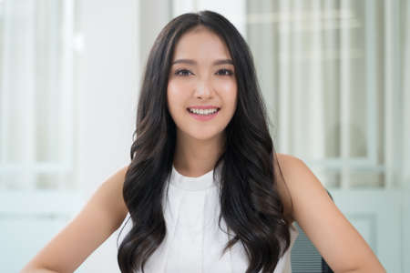 Close up portrait young Asian woman smiling in officeの写真素材