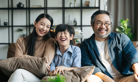 Portrait of happy Asian family spending time together on sofa in living room. family and home concept.の写真素材